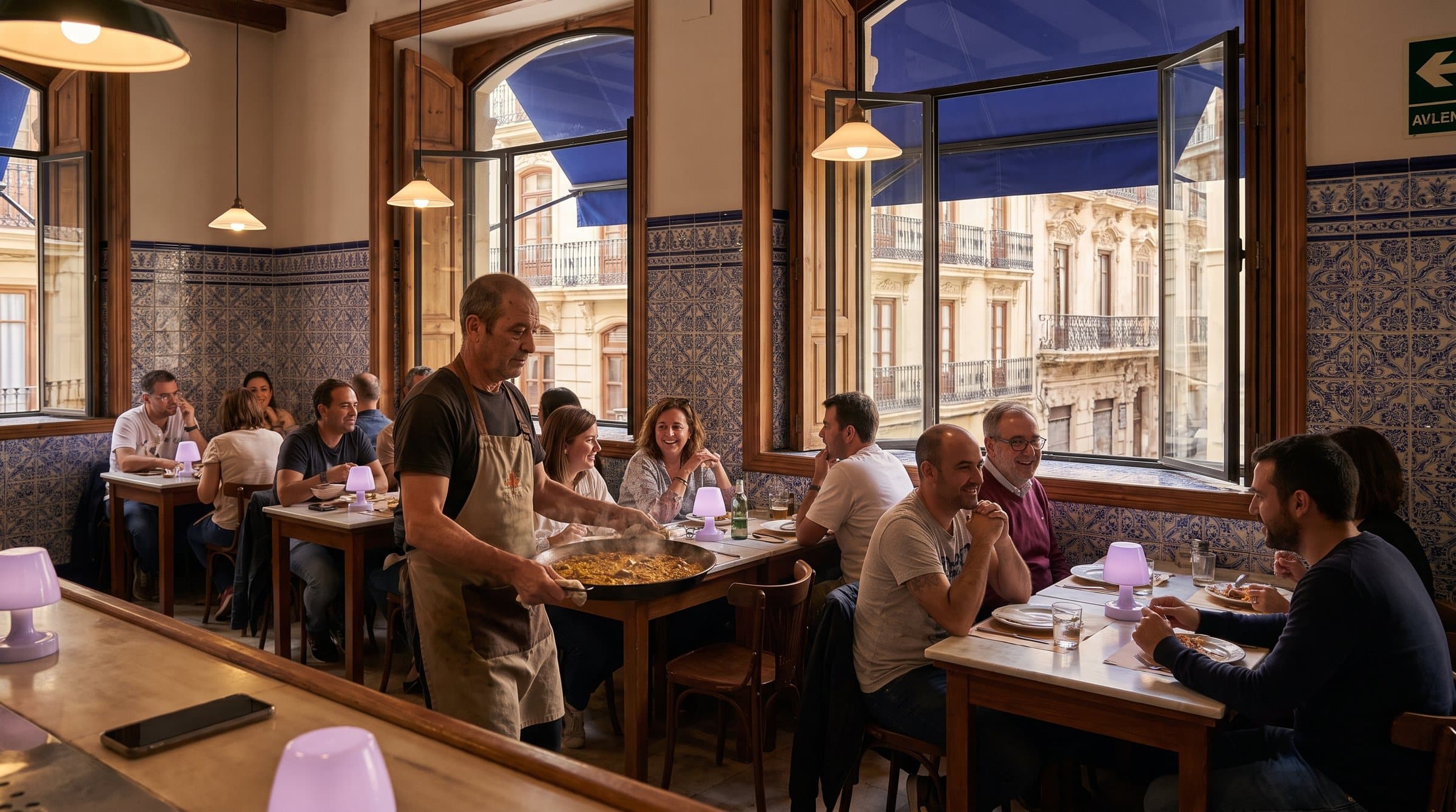 Camarero con una paellera en un restaurante tradicional de Valencia a mediodía